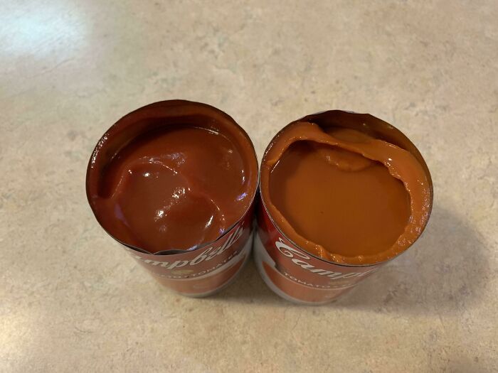 Two Cans Of The Same Tomato Soup From The Same Store. One A Product Of Canada, The Other A Product Of USA