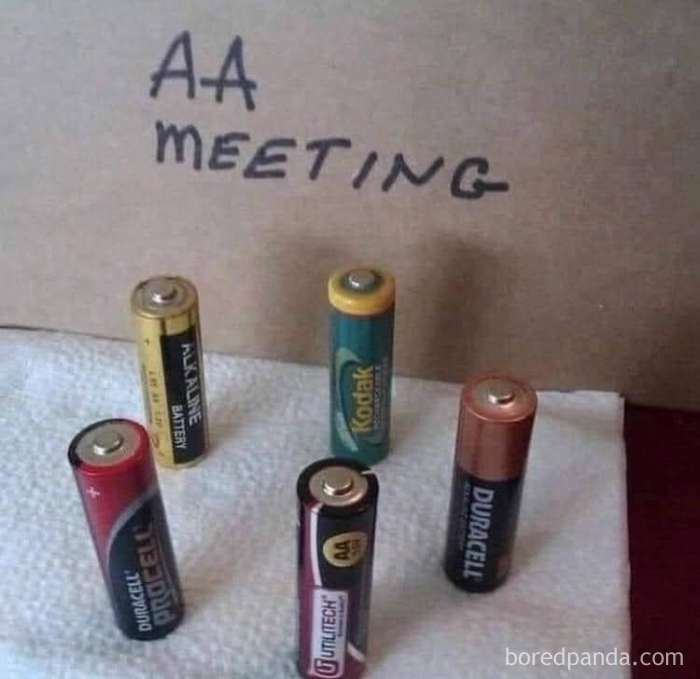 Five AA batteries arranged as if in a meeting, with a sign reading "AA Meeting," creating a literal meme.