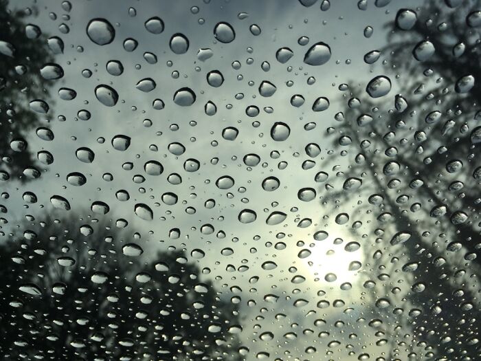 Raindrops On A Glass Pane With The Sun Behind Them..