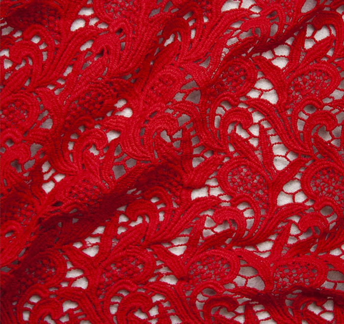 Close-up of intricate red lace fabric with detailed patterns illustrating unique texture for weird laws content.