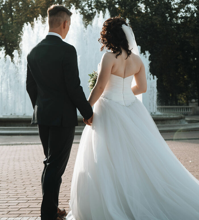 Bride and groom holding hands near a fountain, illustrating unique and weird laws from around the world.