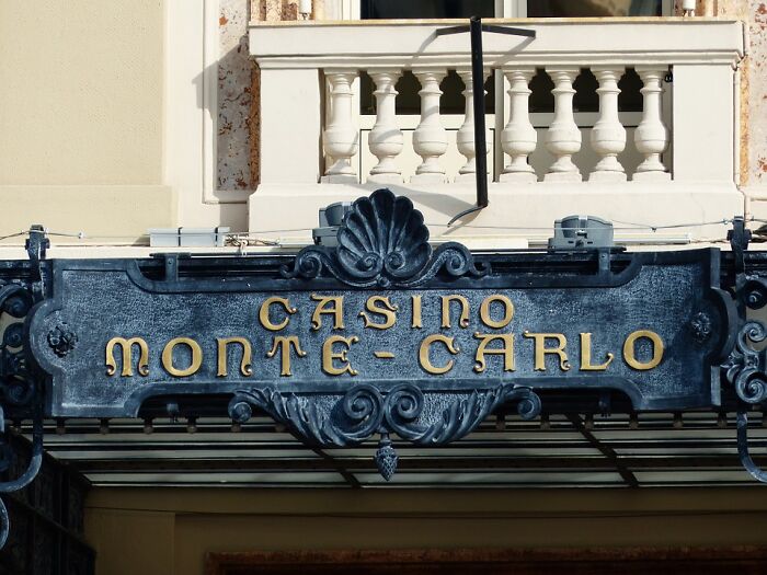 Casino Monte Carlo entrance sign in ornate metalwork, illustrating one of the weird laws from around the world.