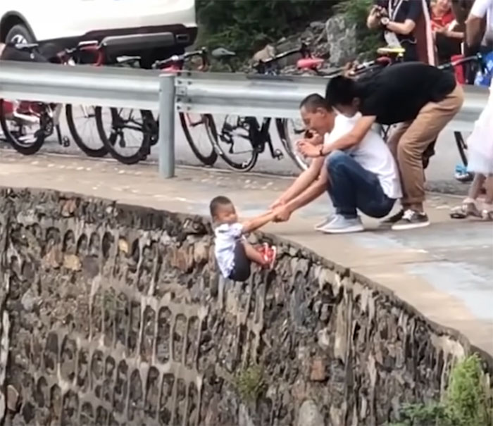 Parents In China Drag Their Child On Edge Of Hill Just To Take Photos