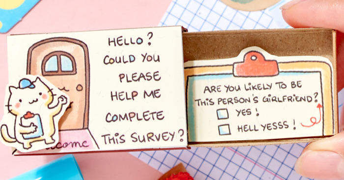 Hand holding a cute illustrated card with a playful girlfriend survey, featuring cartoon cat and checkboxes.