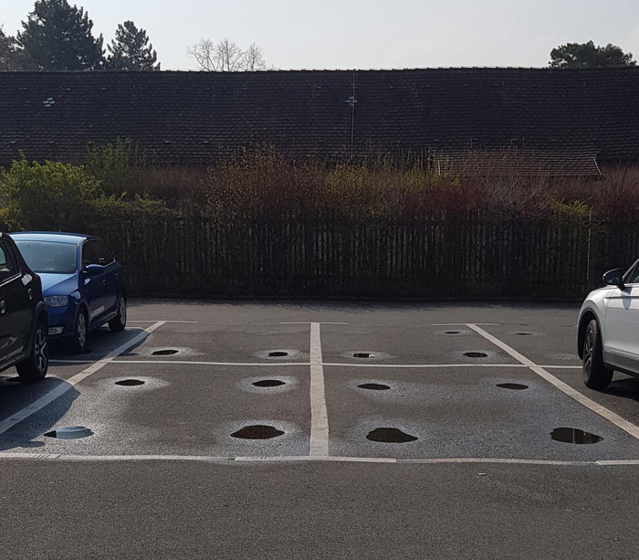 Puddles After Rain Show The Spots Where The Wheels Are In This Parking Lot