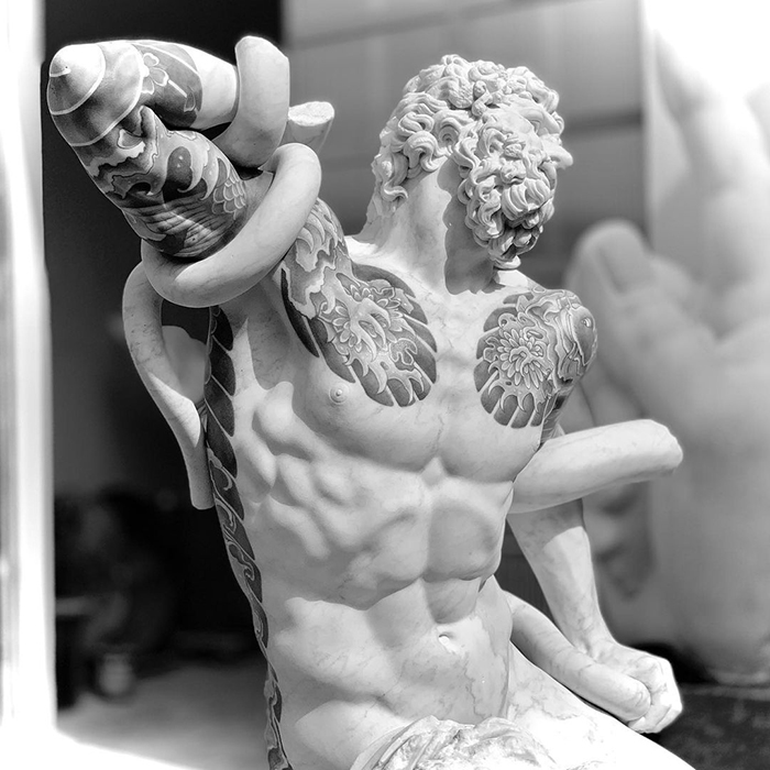 Sculpture with intricate tattoos, showcasing Italian artist's creativity beyond human skin.