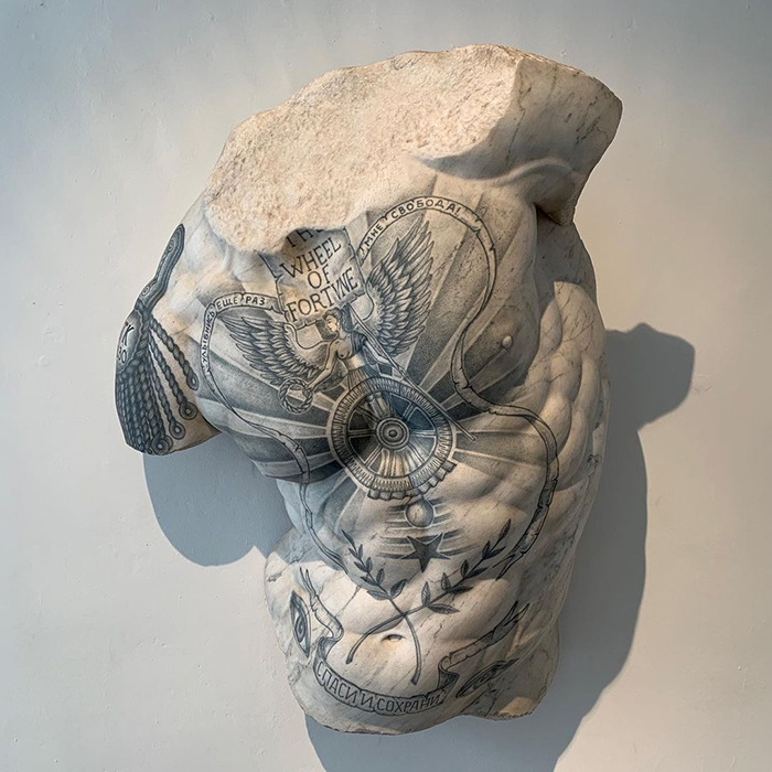 Tattooed Italian sculpture featuring intricate designs on a marble torso, showcasing art beyond skin.