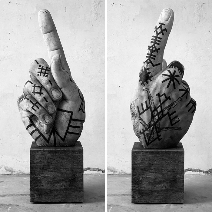 Sculpture of a hand with black tattoos by Italian artist, showcasing tattoos beyond skin on artistic sculptures.