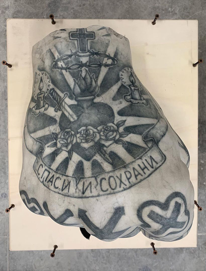 Tattooed sculpture with intricate designs, showcasing Italian artist's unique art style beyond human skin.