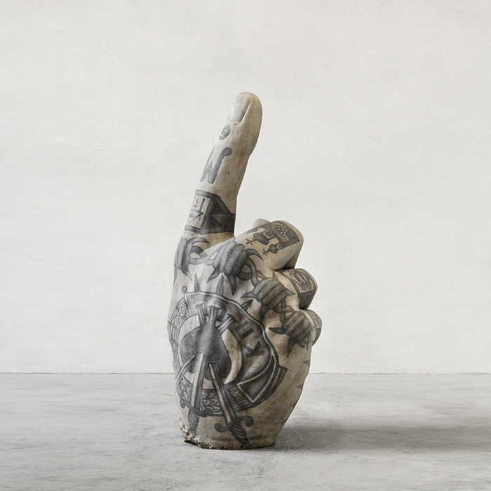 Sculpture of a hand adorned with intricate tattoos, showcasing Italian artist's creativity beyond skin.