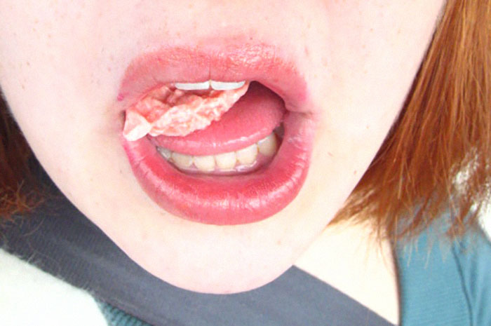 Close-up of a person with gum stuck to their lips, illustrating one of the specific little things that are so irritating.