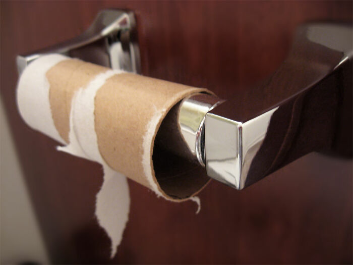 Empty toilet paper roll on a shiny metal holder, illustrating one of the irritating little things people can’t stand.