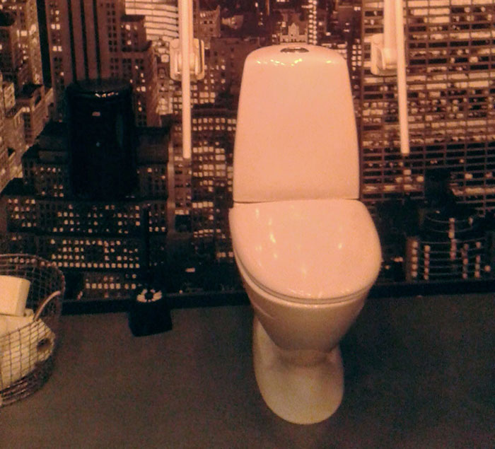 White toilet in a small bathroom setting illustrating one of the specific little things that are so irritating to people