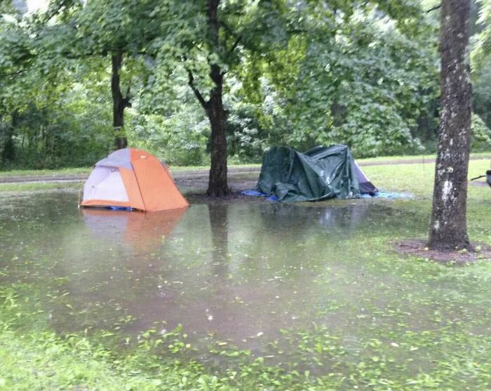 Flooded campsite with tents surrounded by water and trees, showcasing nature moments that make people go well that s***s.