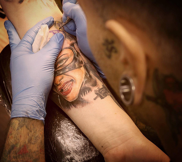 Tattoo artist works on a detailed tattoo, showcasing vibrant inkwork at a parlor. Tattoo artist works on a detailed tattoo, showcasing vibrant inkwork at a parlor.