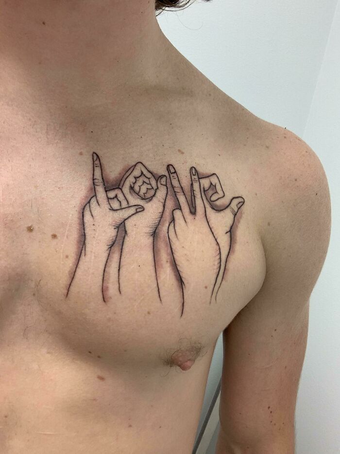 Tattoo cover-up of scars on chest with hand gestures design.