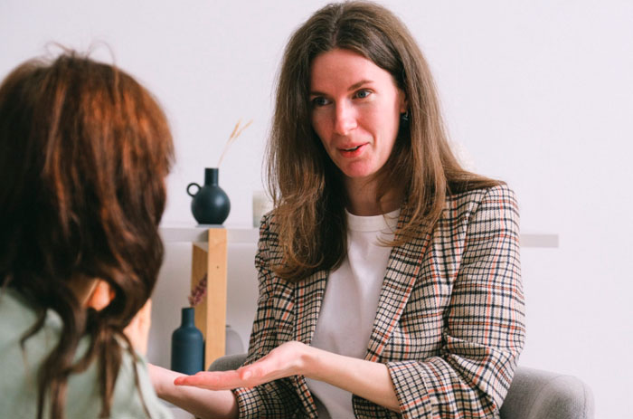 Woman in therapy session engaging in a meaningful conversation as spot-on questions from therapists are shared.
