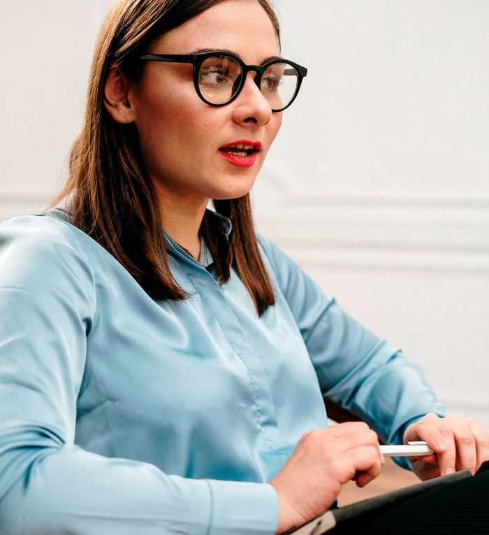 Woman in glasses during a therapy session, reflecting on spot-on questions that made everything click.