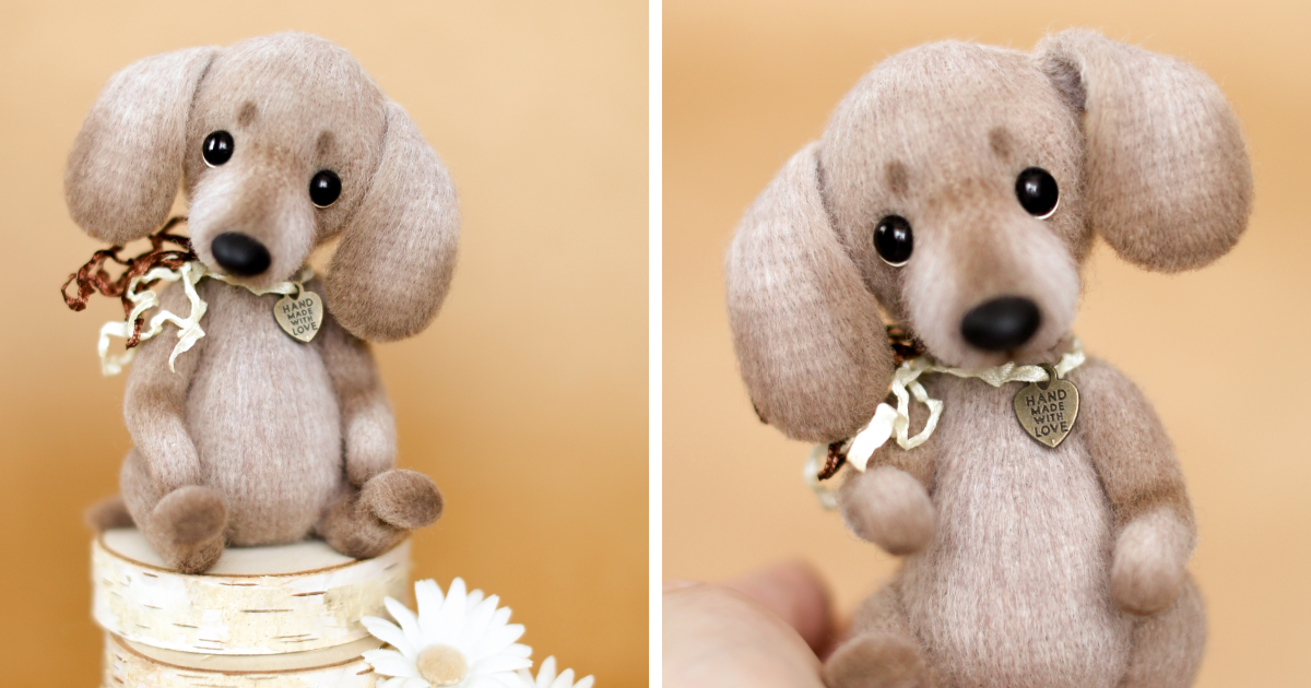 Soft crochet toy dog with big eyes and floppy ears, wearing a handmade love charm and ribbon bow.