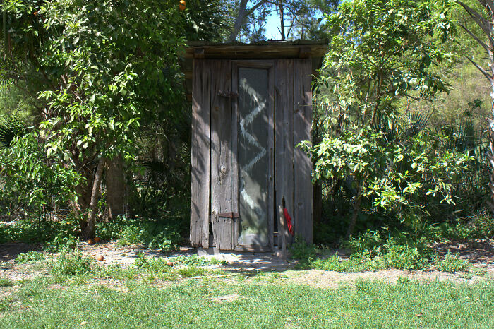 an old wooden outhouse in the yard