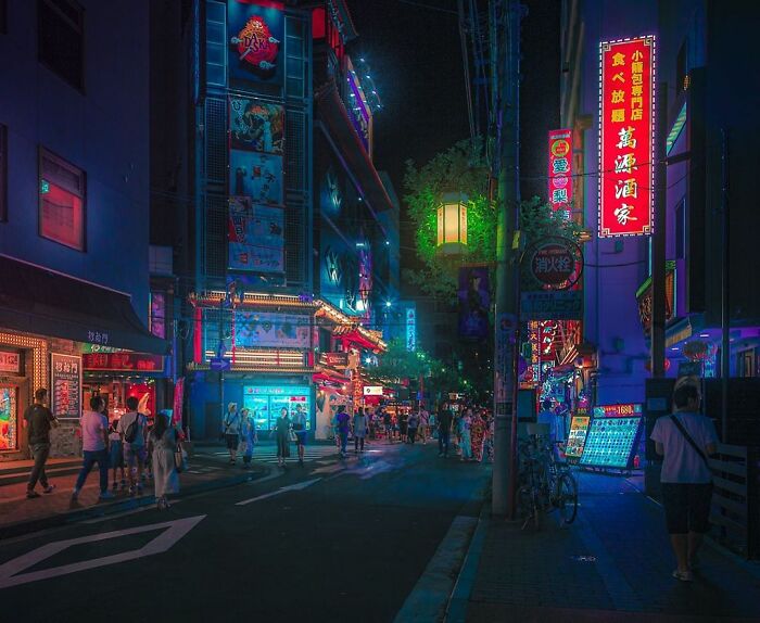 Night street scene in Japan with vibrant neon lights, bustling pedestrians, and colorful signs capturing the beauty of Japan.