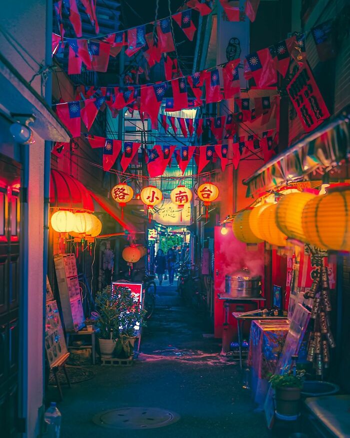 Night alley in Japan illuminated by traditional lanterns and vibrant flags capturing the beauty of Japan's culture and streets.