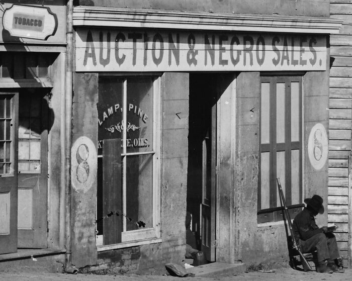 George N. Barnard's 1864 Photograph Of A Slave Trader's Business On Whitehall Street, Atlanta, Georgia, Shows A United States Colored Troop Infantryman [corporal] Just By The Door.