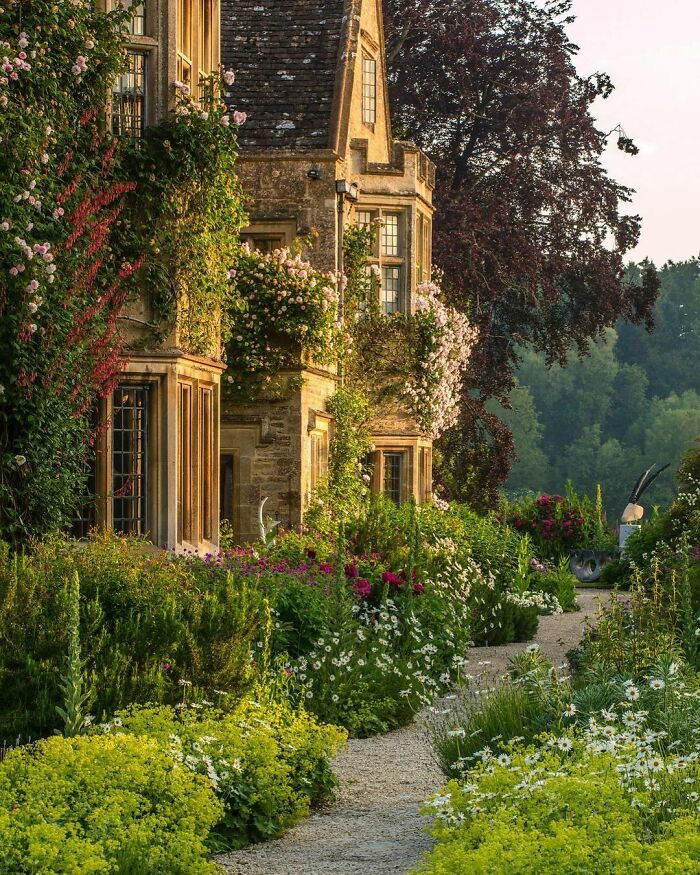 English Country Garden Surrounding Asthall Manor, A Gabled Jacobean Cotswold Manor House Originally Built In The 1620s And Later Altered And Enlarged In The 1910s. Asthall, Oxfordshire, England