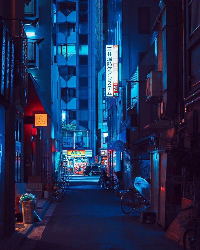 Nighttime urban street in Japan illuminated by neon signs and city lights, showcasing the beauty of Japan’s vibrant atmosphere.