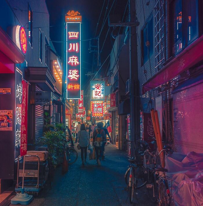 Night street scene in Japan with neon signs and people walking, capturing the beauty of Japan in an urban setting.