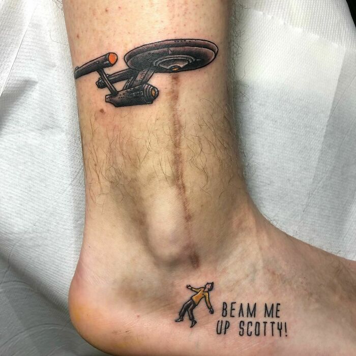 Tattoo covers scar with spaceship design and "Beam me up Scotty" text.