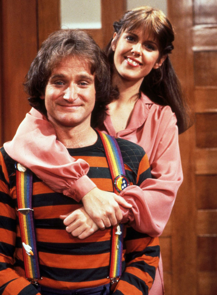 Mindy hugging Mork from the back