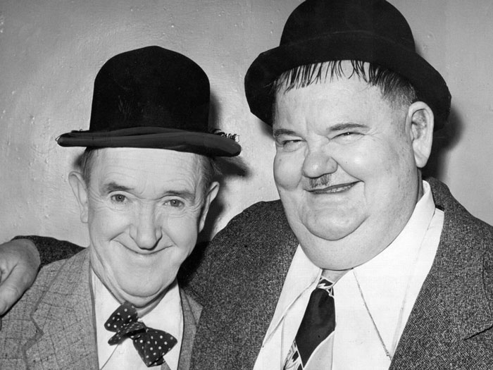 Laurel and Hardy next to each other smiling