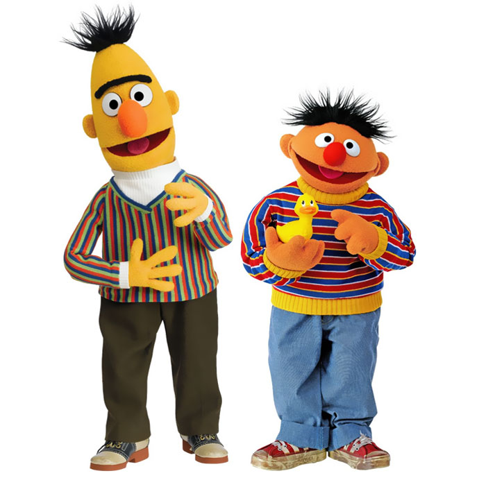 Bert and Ernie smiling and standing next to each other 