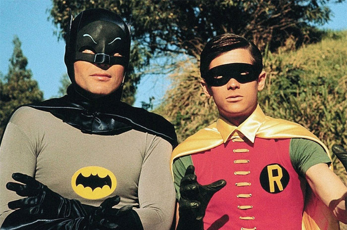 Batman and Robin standing next to each other outside