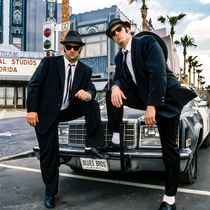 The Blues Brothers standing by the car next to each other