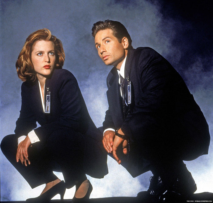 Dana Scully and Fox Mulder crouching next to each other