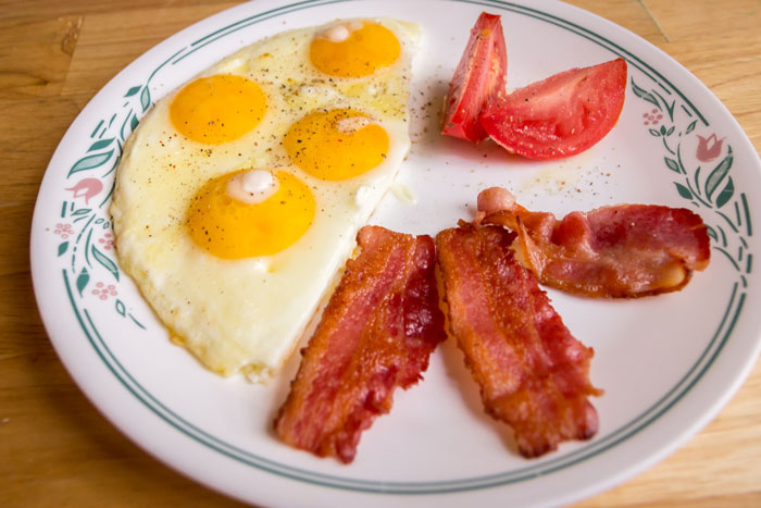 Bacon and eggs with tomatoes on a plate