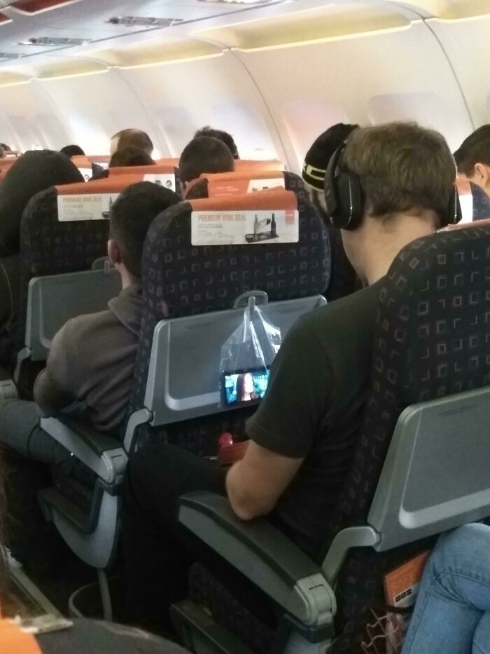 Esta genialidad fue tomada en un avión. Usando una bolsa de plástico transparente para sostener su teléfono