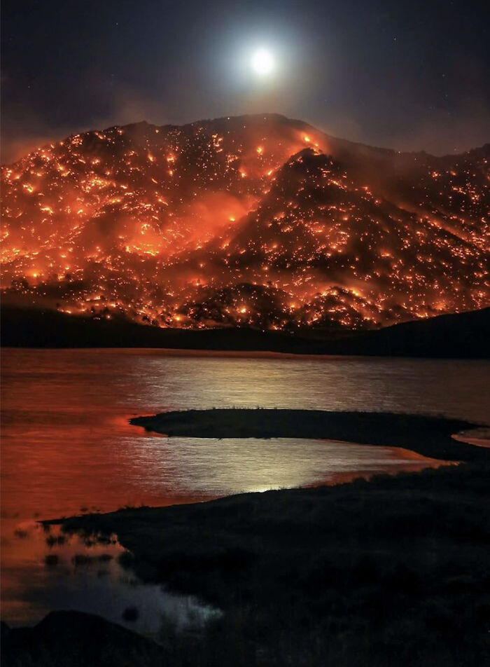 The Moon Rising Over A Hill In California That Is Engulfed In A Wildfire Looks Really Eerie