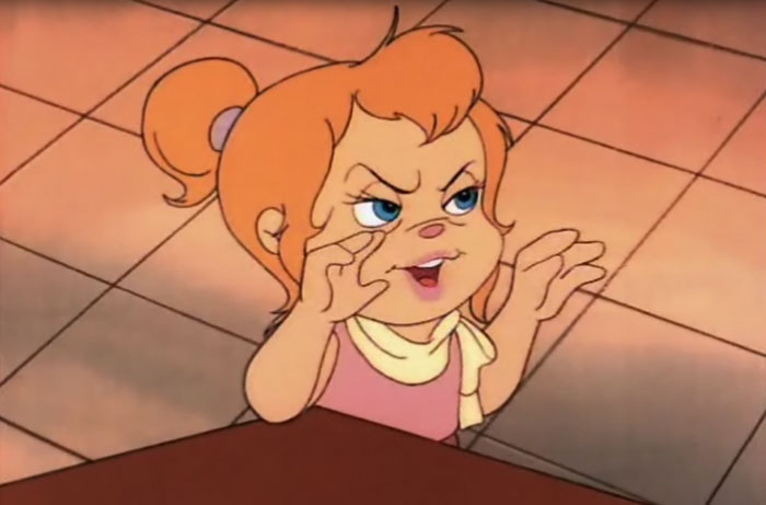 Cute animated character with orange hair and a playful expression gestures excitingly.