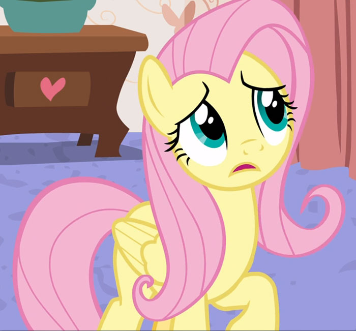 Cute animated character with pink mane and tail, looking surprised in a cozy room.