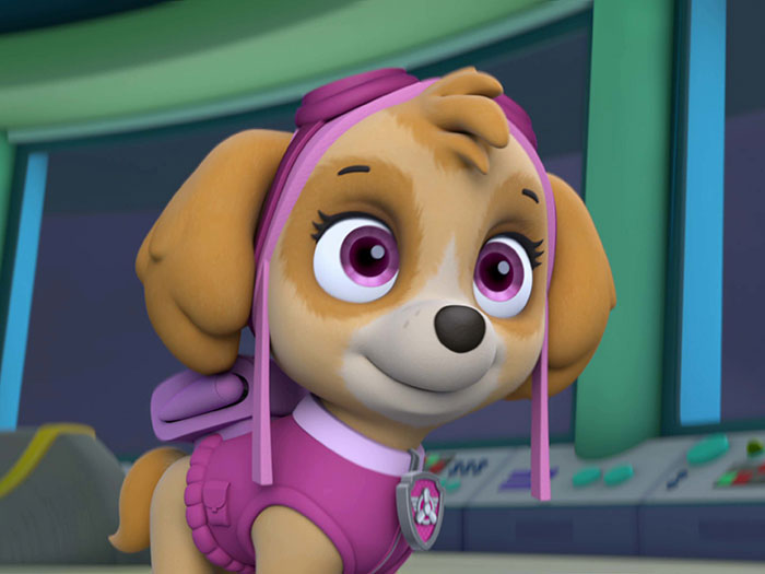 Cute animated character with big pink eyes, wearing a purple outfit and helmet, looking adorable in a colorful setting.