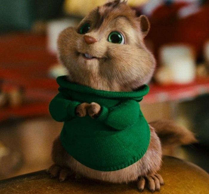 Cute animated character in a green sweater, sitting with a joyful expression.