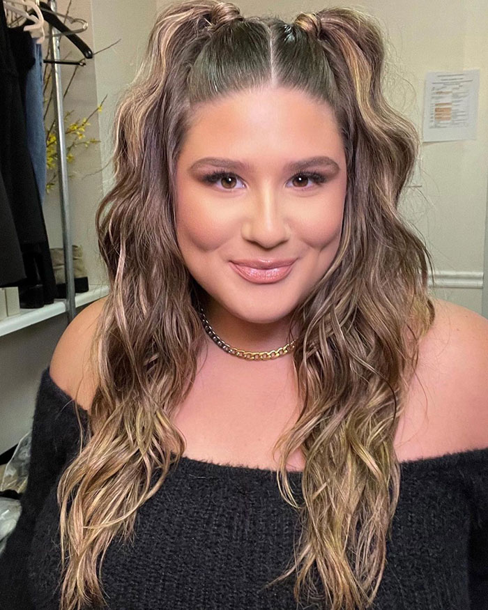 Woman smiling with wavy hair recreating Zara model poses, highlighting their humorous and exaggerated nature. Woman smiling with wavy hair recreating Zara model poses, highlighting their humorous and exaggerated nature.