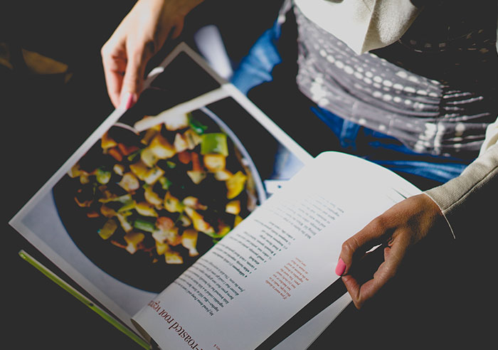 Person reads cookbook recipe