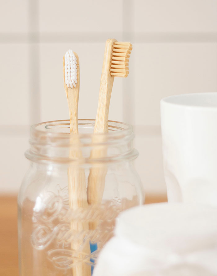 Two brown wooden toothbrushes