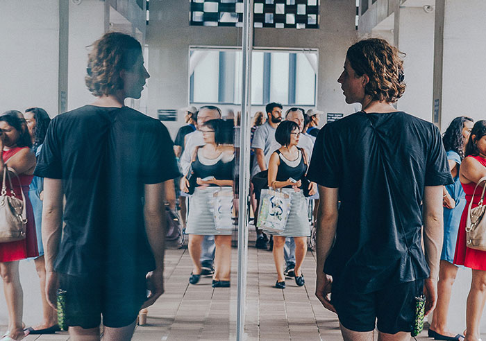 Man walking beside mirror 