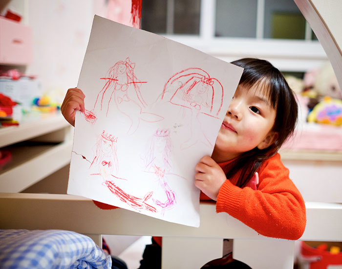 Girl holding paper with drawing