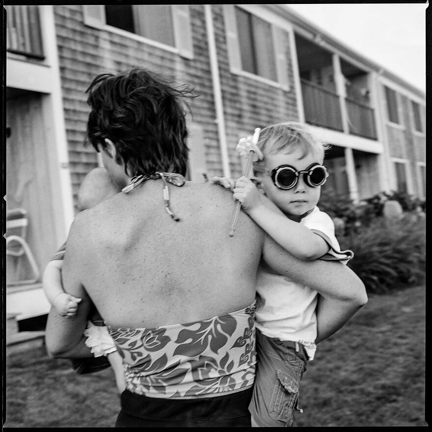 Black and white photo of a woman carrying two children, captured by photographers showing beautiful women around the world.